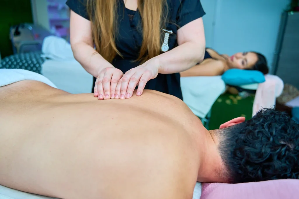 A professional therapist providing a relaxing back massage to a client at a spa, showcasing one of the methods for achieving back pain relief fast through therapeutic techniques.