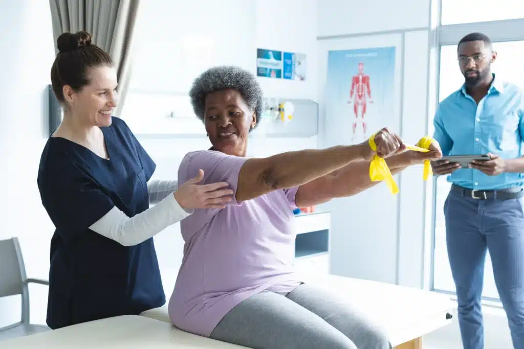 A senior female patient performing rehabilitation exercises with assistance, recovering from spinal fusion surgery involving rods and screws.