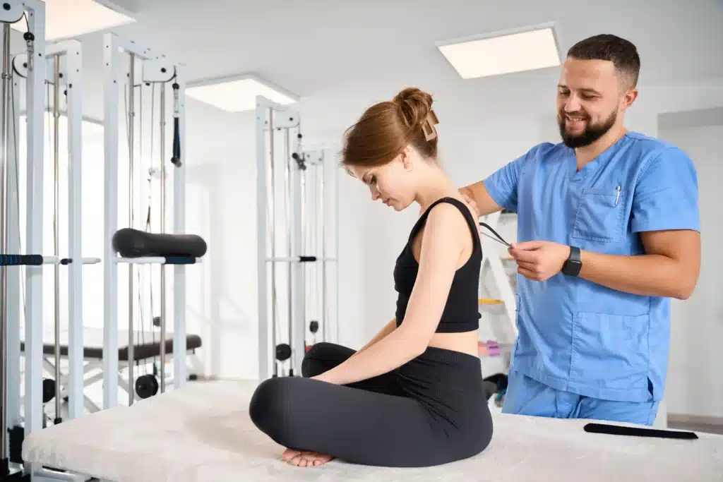 A kinesiologist applying kinesiology tape to support recovery after spinal fusion rods and screws surgery.