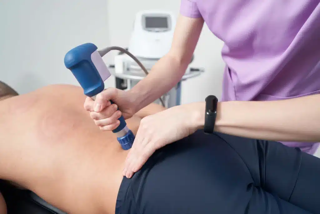 Male patient undergoing back pain laser treatment for rehabilitation therapy.