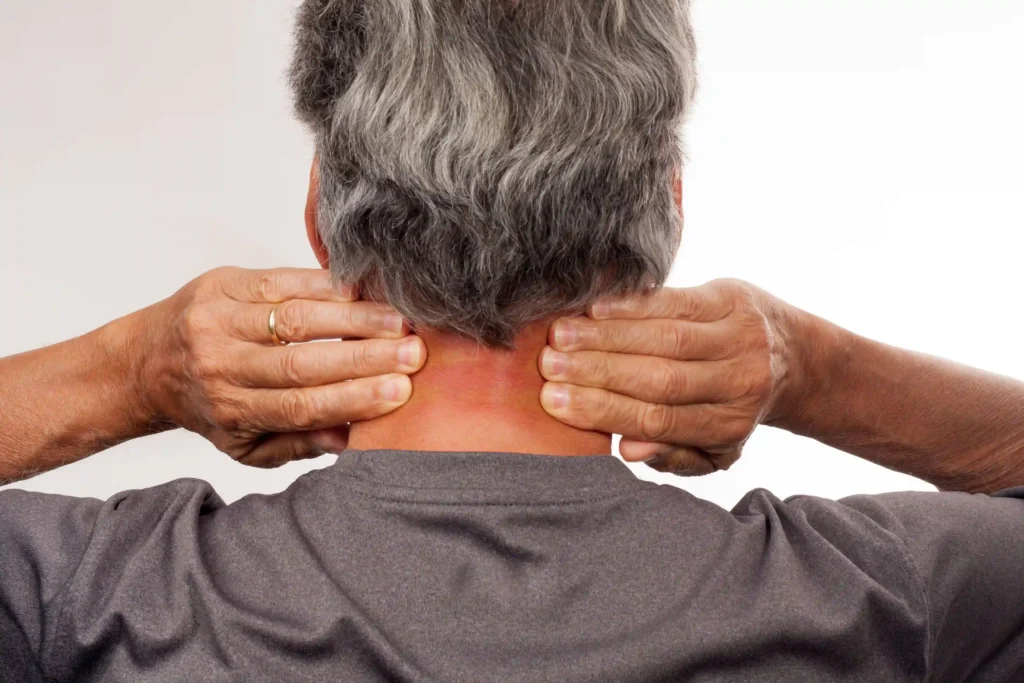 Older man stretching his neck using the McKenzie Method for pain relief and mobility improvement.