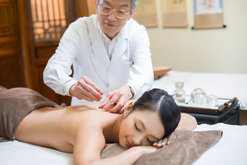 A young woman receiving acupuncture physical therapy to alleviate muscle tension and improve mobility